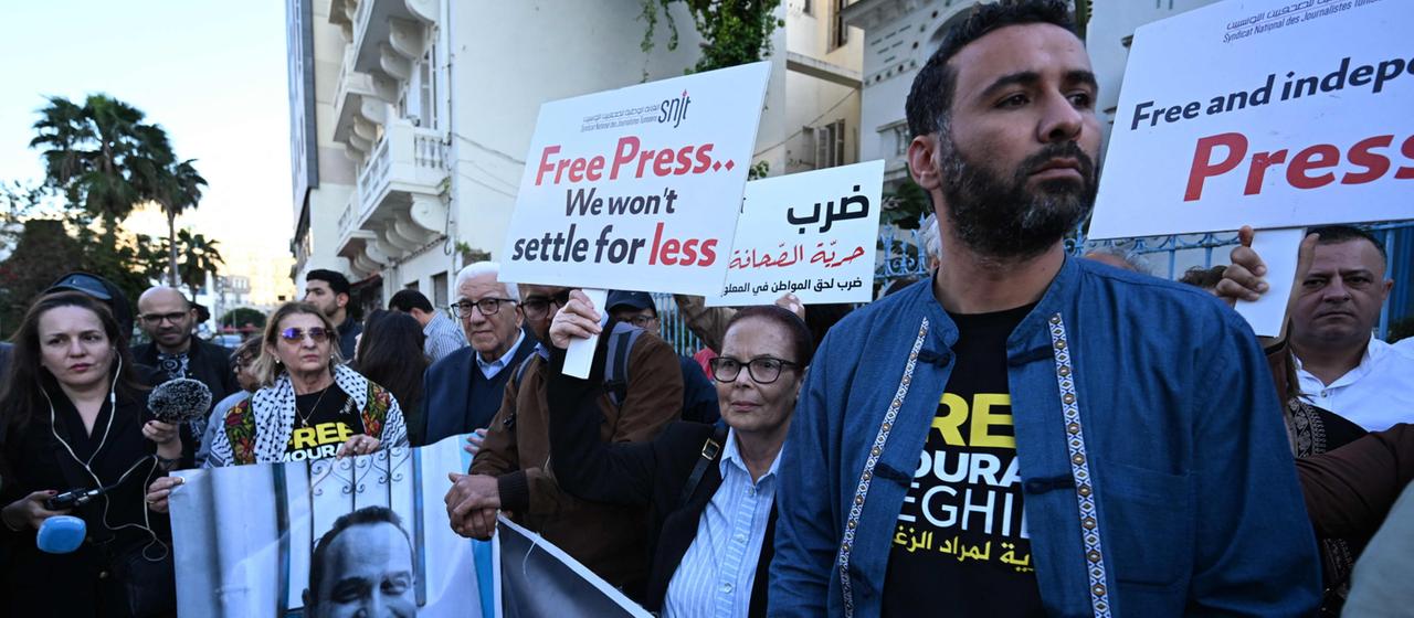 Journalisten demonstrieren in Tunis für die Pressefreiheit und halten dabei Plakate hoch.