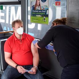 Ein Mann lässt sich in einem Bus in Kiel impfen.
