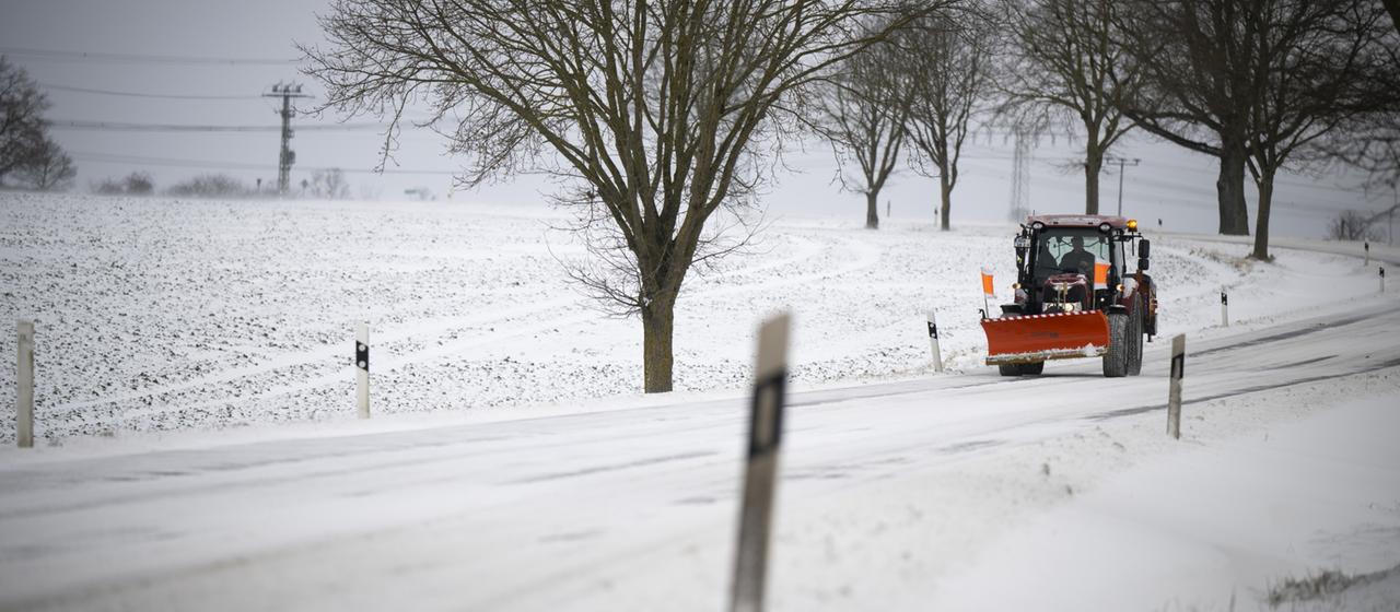 Ein Räumfahrzeug fährt über eine schneebedeckte Straße in Mecklenburg Vorpommern