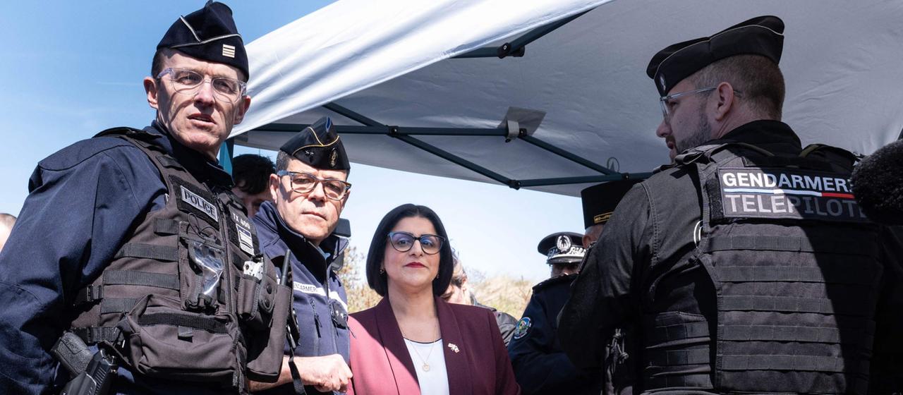Die britische Innenministerin Shabana Mahmood spricht mit französischen Polizisten.