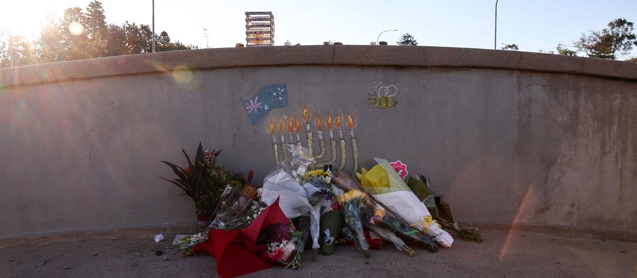 Blumen sind an einer Mauer am Bondi Beach niedergelegt.