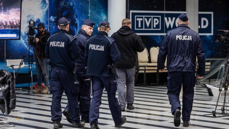 Polizisten betreten das Gebäude des Senders TVP.