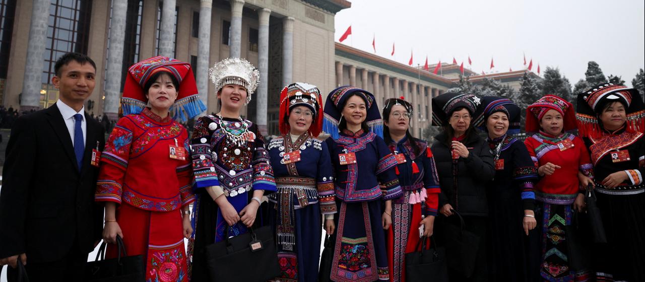 Delegierte des Nationalen Volkskongresses in Trachten vor der Großen Halle des Volkes.