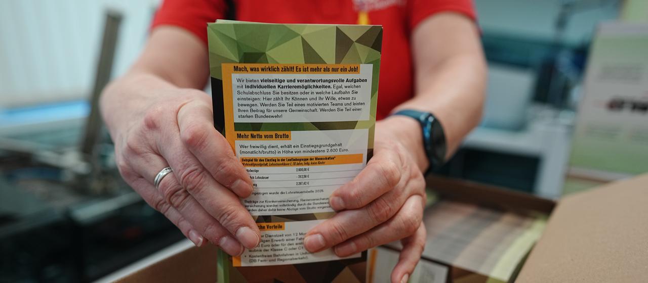 Mitarbeitende sortieren die ersten Briefe mit Broschüren für den neuen Wehrdienst. 