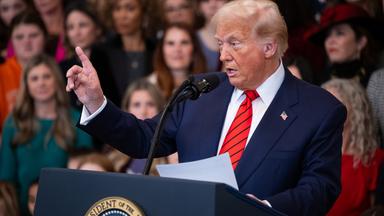 Donald Trump hebt während einer Rede einen Zeigefinger.