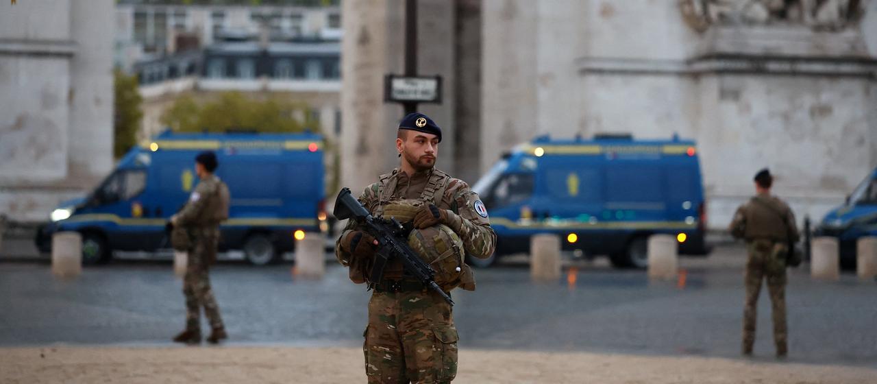 Ein Soldat mit Gewehr vorm Arc de Triomphe