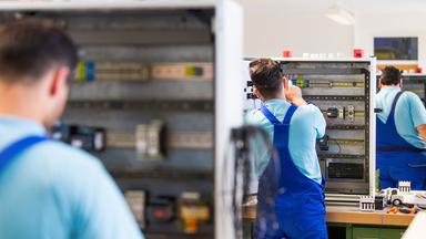 Fachkräfte arbeiten an Schaltschränken.