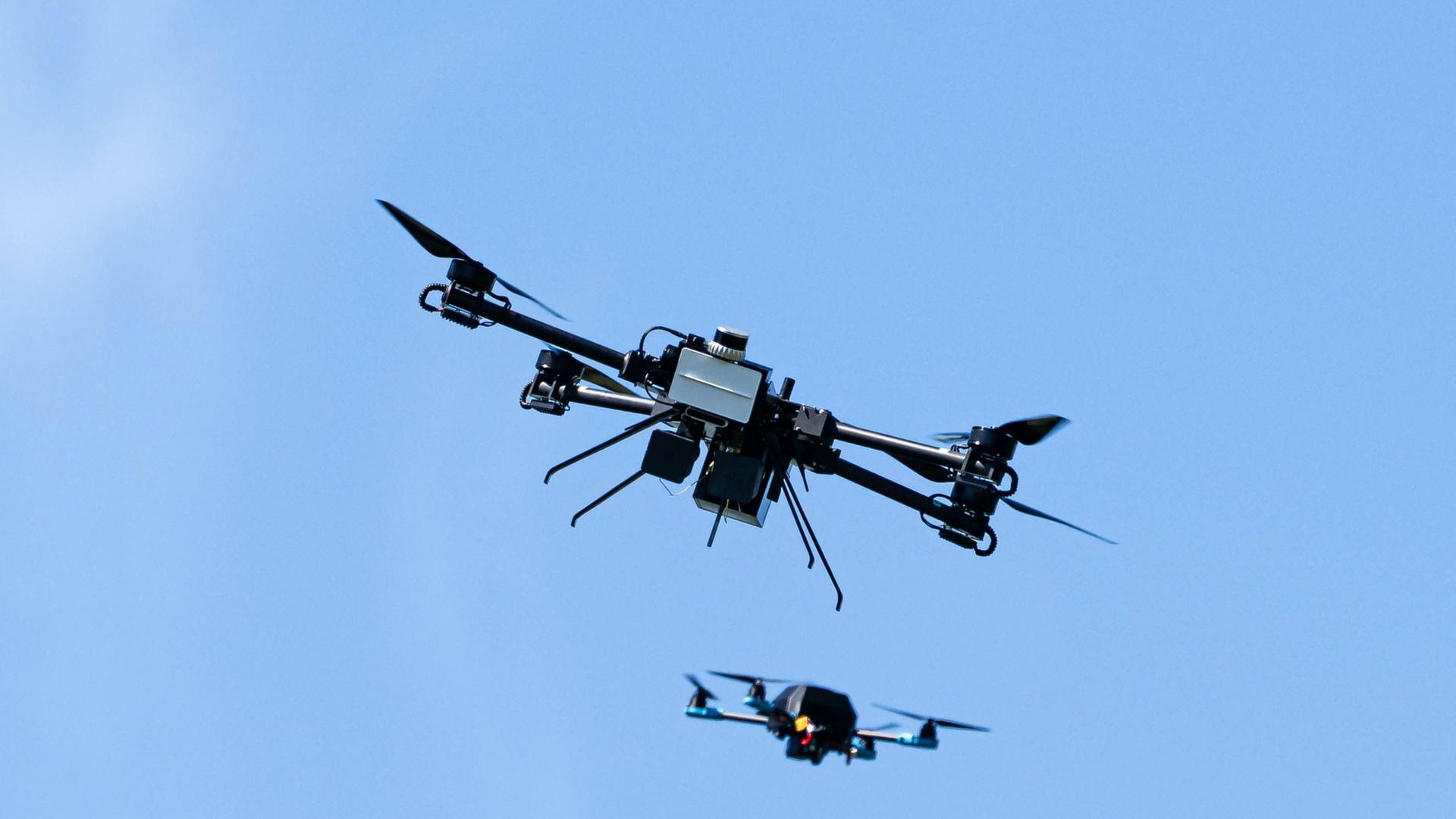 Eine Drohne von Argus Interception jagt eine kleine Drohne, um diese mit einem Netzt einzufangen. | Sina Schuldt/dpa