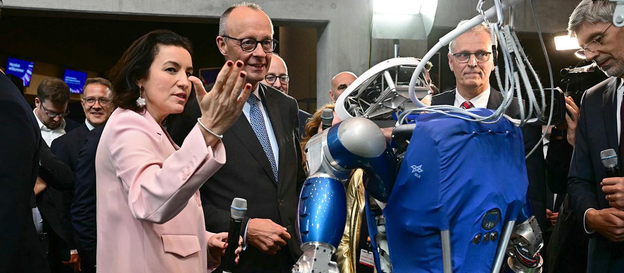 Dorothee Bär und Friedrich Merz betrachten den humanoiden Laufroboter TORO. | dpa Dorothee Bär und Friedrich Merz betrachten den humanoiden Laufroboter TORO.