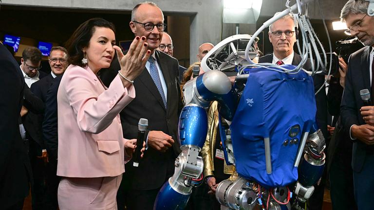 Dorothee Bär und Friedrich Merz betrachten den humanoiden Laufroboter TORO.