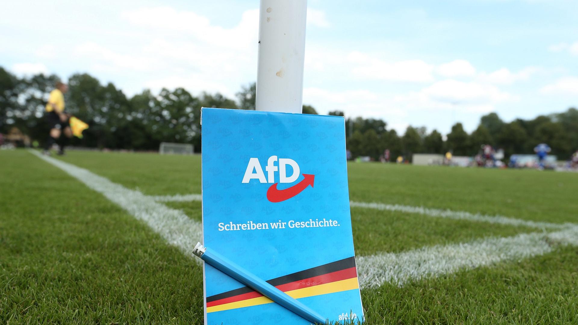 An der Eckfahne eines Fußballplatzes steht ein Notizblock der Partei Alternative für Deutschland.  | IMAGO / Hanno Bode