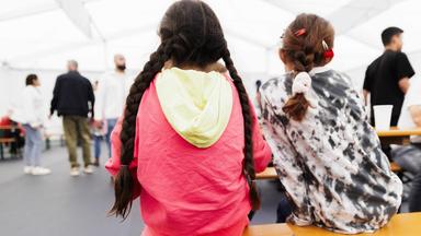 Geflüchtete Mädchen sitzen beim Essen in einem Aufenthaltsraum vom Gelände des Ankunftszentrums Tegel.