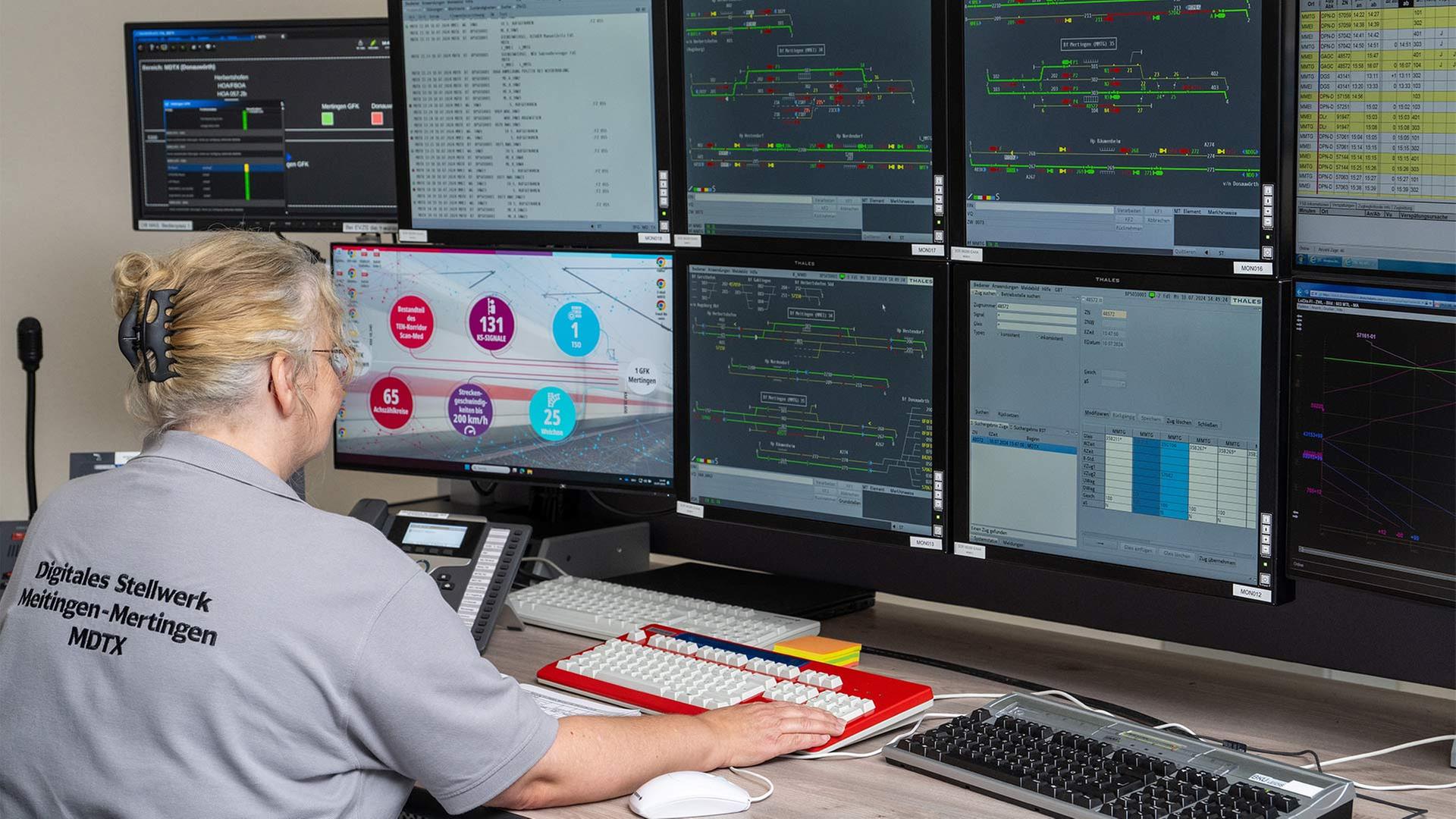 Eine Fahrdienstleiterin sitzt an Steuerbildschirmen eines digitalen Stellwerks. | picture alliance/dpa
