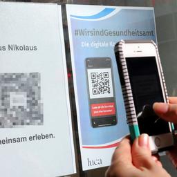 Eine Kundin scannt den QR-Code der Luca-App zur Kontaktnachverfolgung.