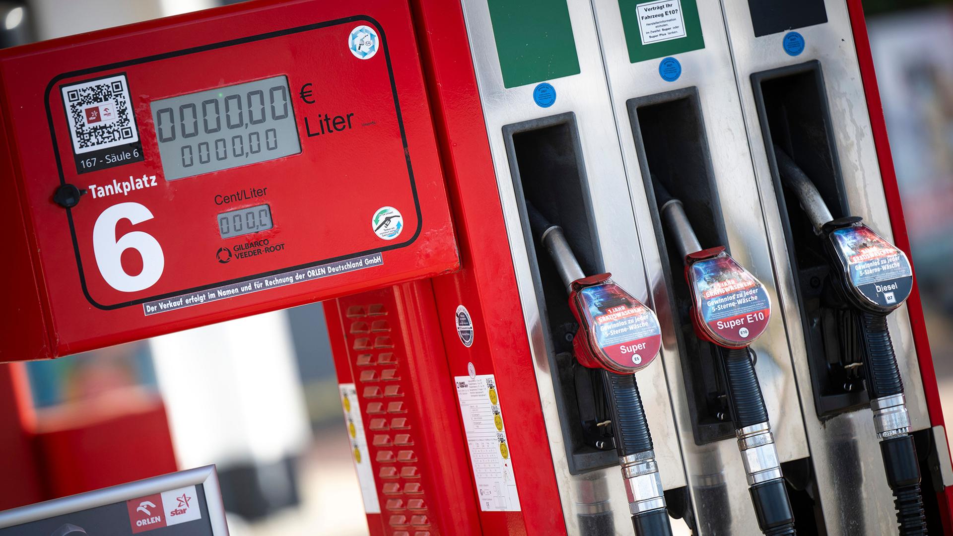 An einer Zapfsäule an einer Tankstelle hängen die Tankschläuche der Kraftstoffe. | Philip Dulian/dpa