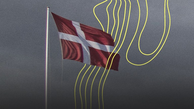 Eine Dänemarkflagge vor dunklen Regenwolken.