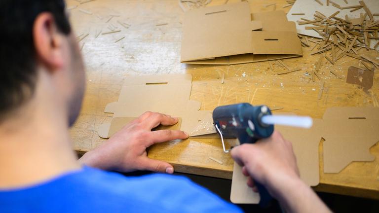 Ein junger Häftling klebt Kartons im Arbeitsbereich der Jugendanstalt Hameln. 