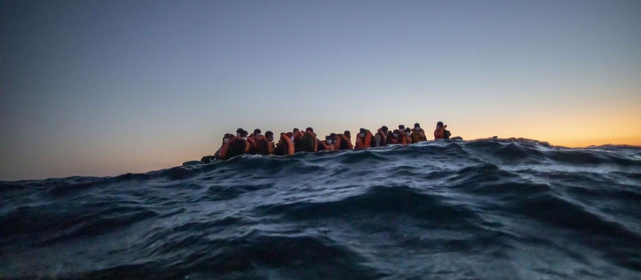 Ein Boot mit Geflüchteten vor der libyschen Küste im Mittelmeer 