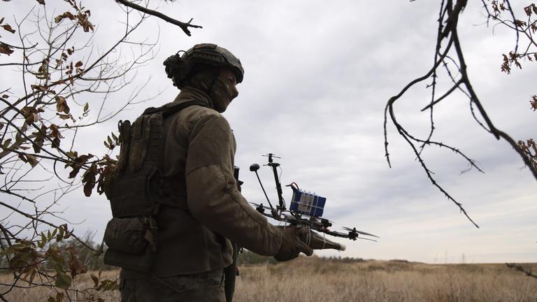 Nahe der Front bei Saporischschja hält ein ukrainischer Soldat eine FPV-Drohne in der Hand.