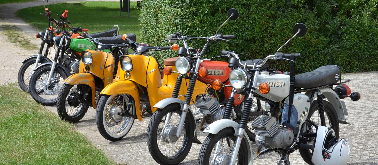 Simson-Mopeds stehen nebeneinander.