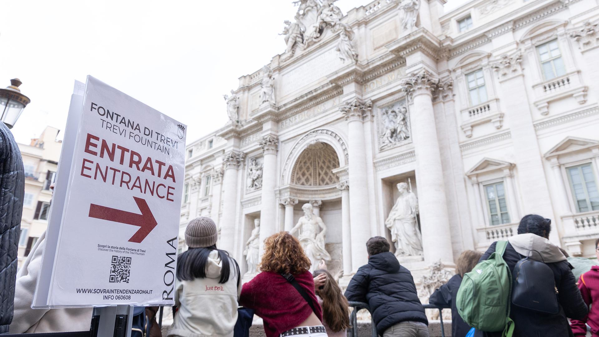 Touristen stehen Schlange, um den Trevi-Brunnen zu sehen. | dpa