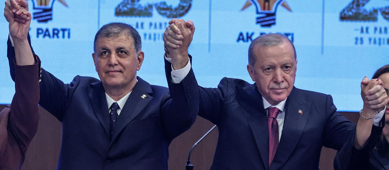Cemil Tugay (links) und Recep Tayyip Erdogan heben ihre gefalteten Hände.