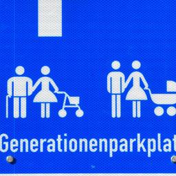 Ein Bild eines Parkschildes von einem Mehrgenerationenparkplatz. Dort ist ein Symbol eines alten Paares mit Rollator sowie einer Familie mit Kinderwagen. 