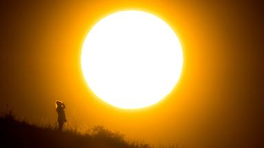 Eine Frau betrachtet den Sonnenaufgang.