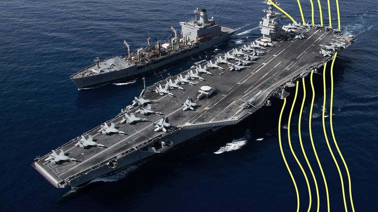 Ein amerikanischer Flugzeugträger fährt neben einem amerikanischen Kriegsschiff über das Wasser