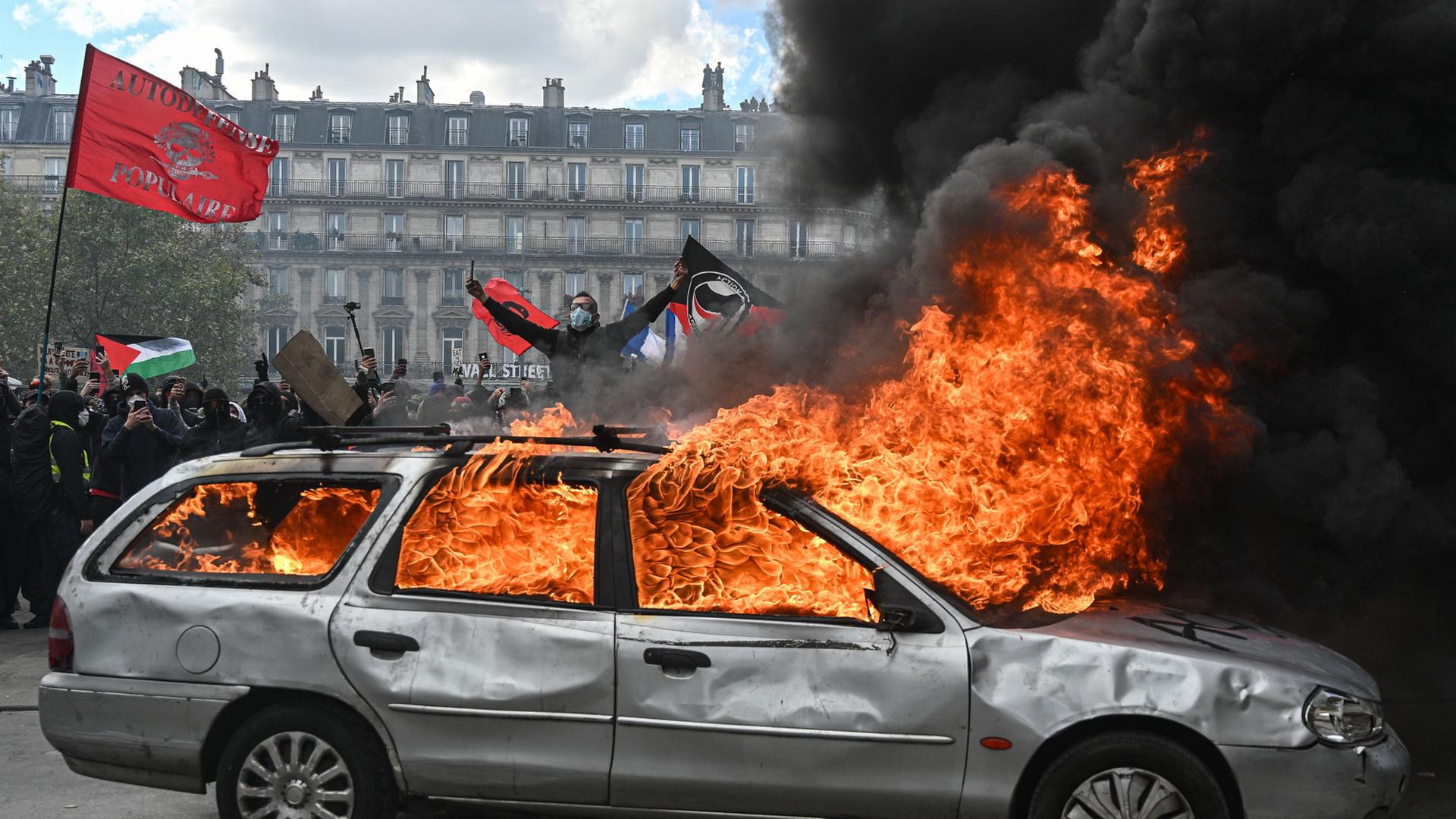Vermummter Randalierer hinter einem brennenden Auto in Paris | Julien Mattia/Le Pictorium via Z