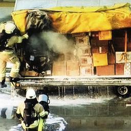 Feuerwehrleute löschen den Brandsatz in einem Paketwagen am Leipziger Flughafen.