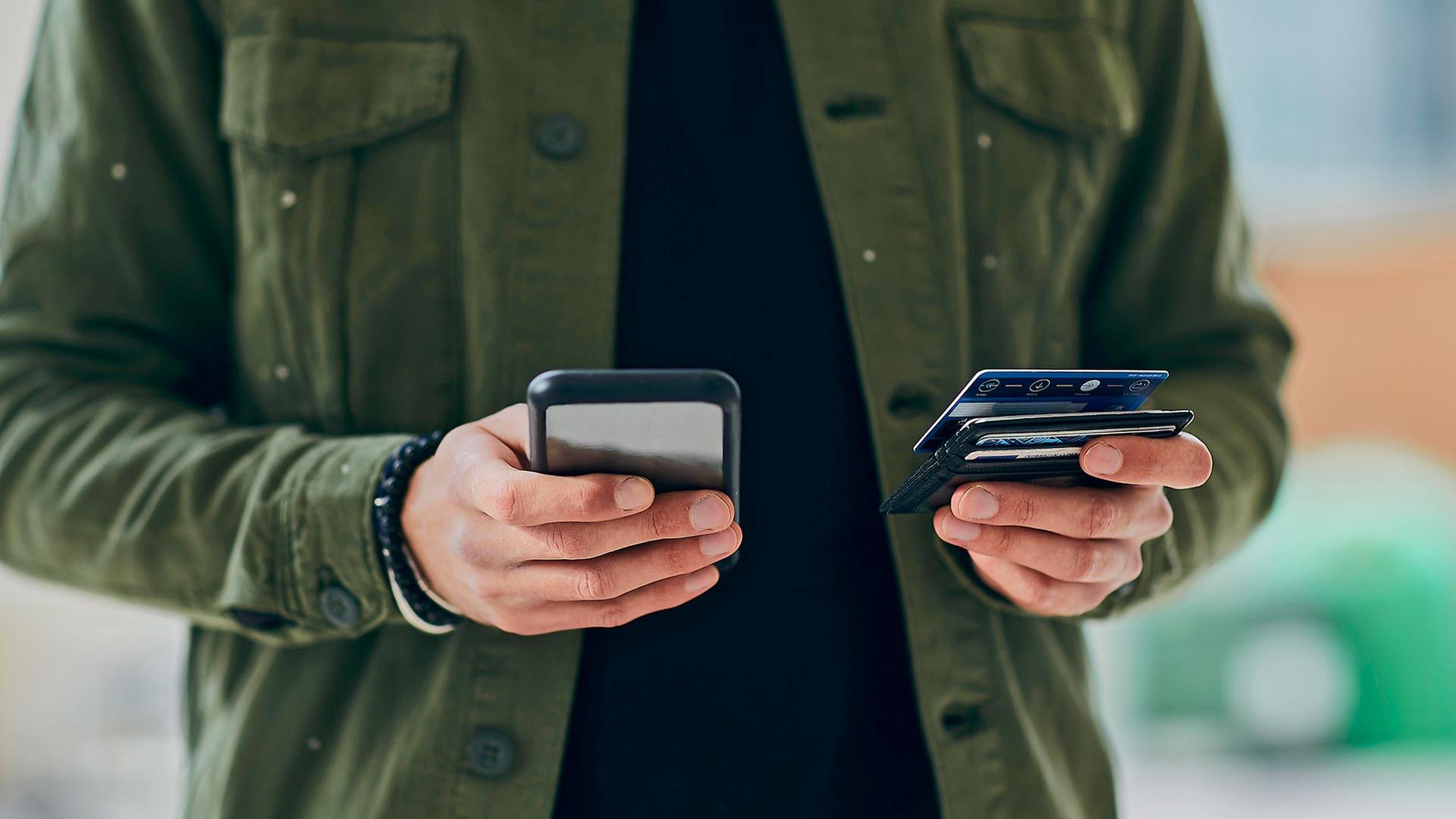 Eine Person hält ein Smartphone und eine Kreditkarte in Händen. | picture alliance / Westend61
