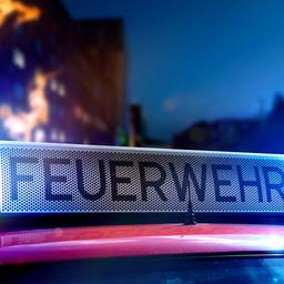Feuerwehrschild auf Feuerwehrauto im Hintergrund Feuer