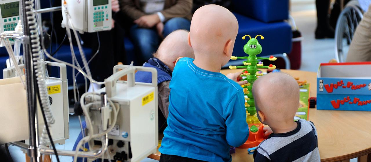 Drei junge Patienten spielen in einer Tagesklinik für Krebspatienten.