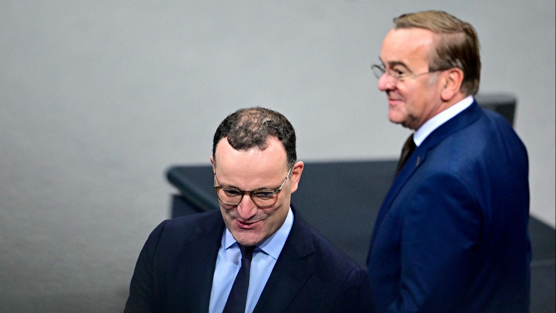 Jens Spahn (CDU) und Boris Pistorius (SPD) unterhalten sich im Bundestag. | AFP