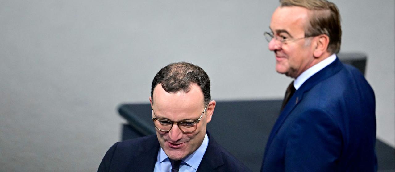 Jens Spahn (CDU) und Boris Pistorius (SPD) unterhalten sich im Bundestag.