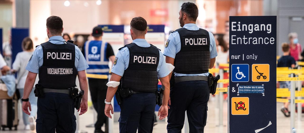Beamte der Bundespolizei gehen an den Sicherheitskontrollen des Flughafens Köln/Bonn vorbei