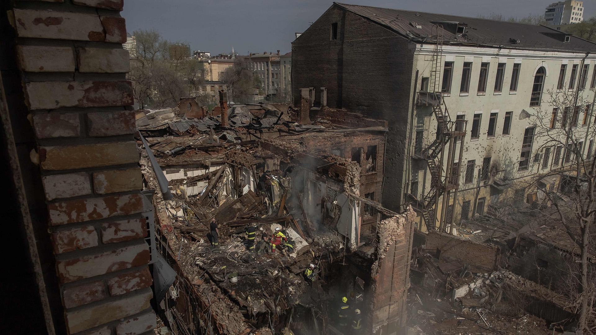 Ukrainische Rettungskräfte sind in Dnipro (Ukraine) an der Stelle schwer beschädigter Gebäude im Einsatz. | AFP