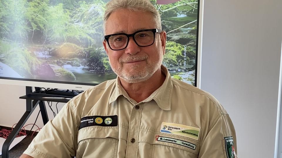 Der Leiter des Nationalparks Eifel, Michael Lammertz, trägt seine Arbeitskleidung und schaut freundlich in die Kamera.