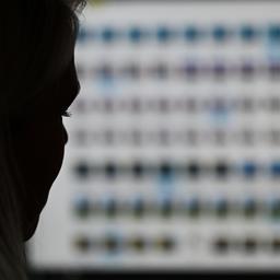 Eine Ermittlerin gegen Kinderpornografie vor einem Monitor mit Fotodateien.