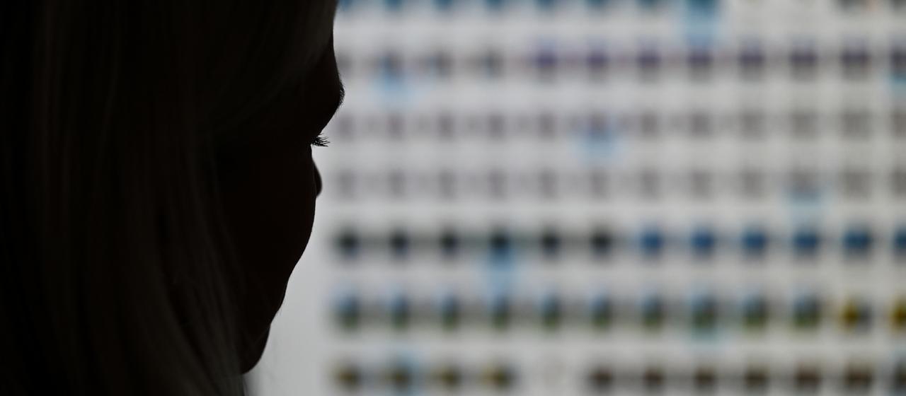 Eine Ermittlerin gegen Kinderpornografie vor einem Monitor mit Fotodateien.