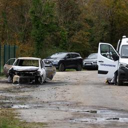  Französische Gendarmen arbeiten in der Nähe eines ausgebrannten Autos.