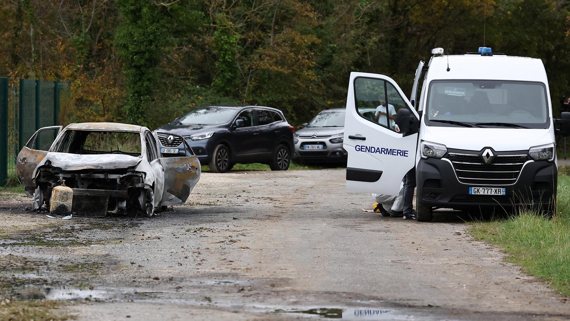  Französische Gendarmen arbeiten in der Nähe eines ausgebrannten Autos. | REUTERS/
