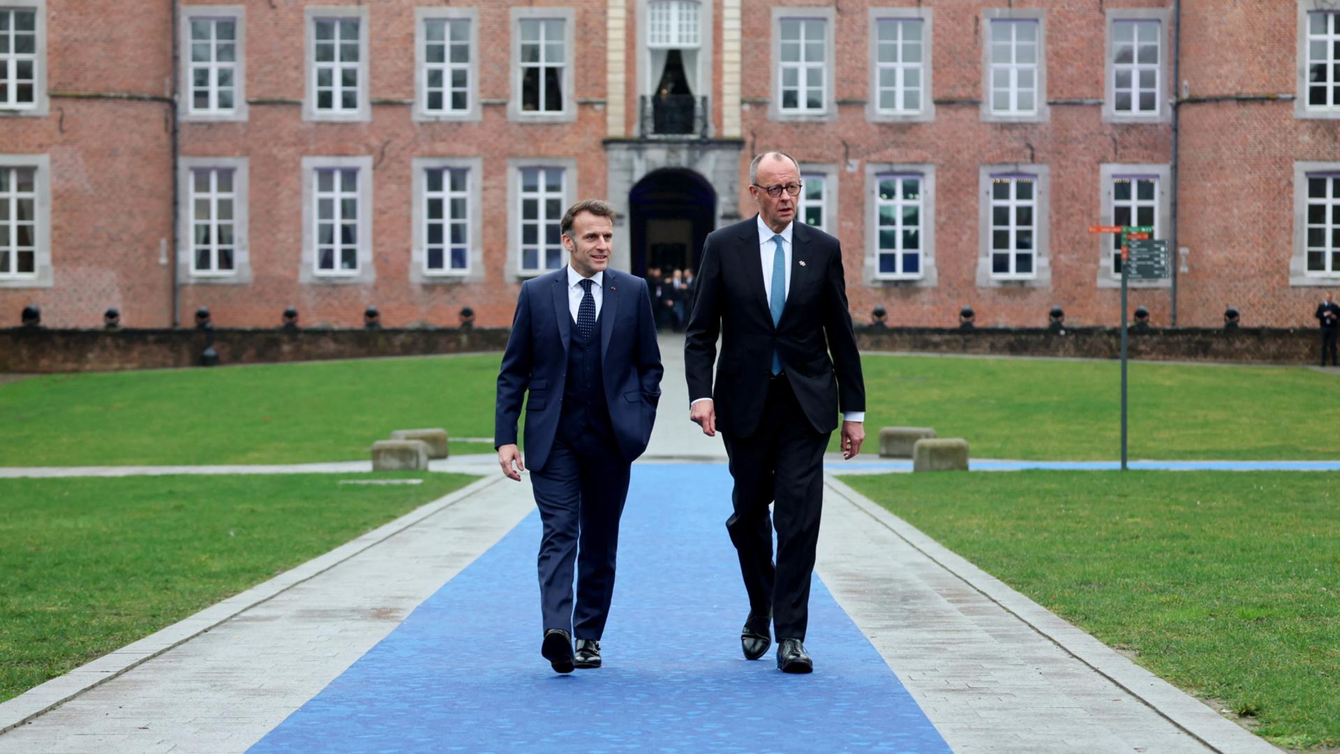 Emmanuel Macron und Friedrich Merz kommen gemeinsam zum EU-Gipfel im belgischen Alden Bielsen. | AFP