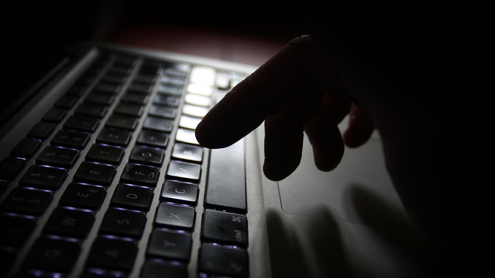 Eine Hand ist �ber der Tastatur eines Laptops zu sehen. | dpa