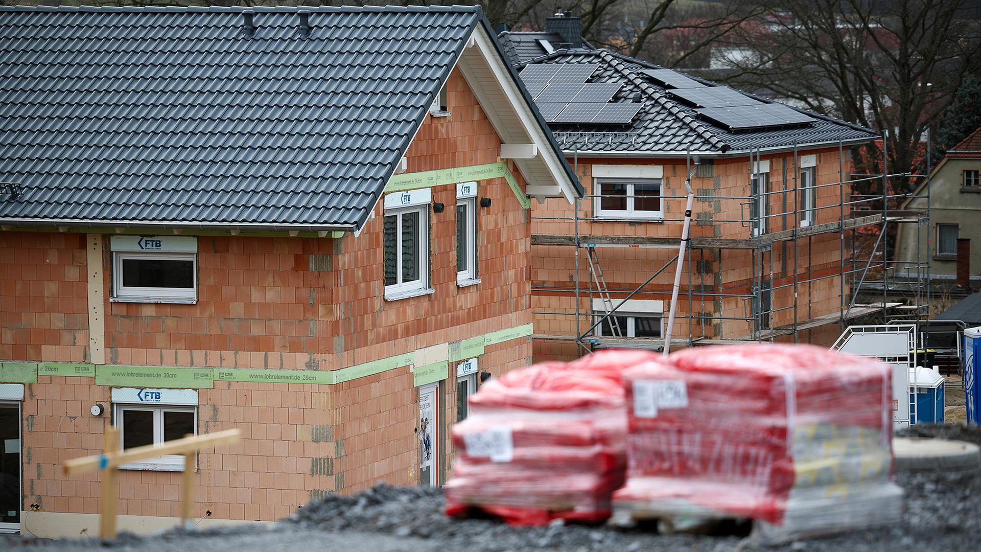 Zwei Einfamilienhäuser entstehen in einem Baugebiet in einer sächsischen Gemeinde. | picture alliance/dpa
