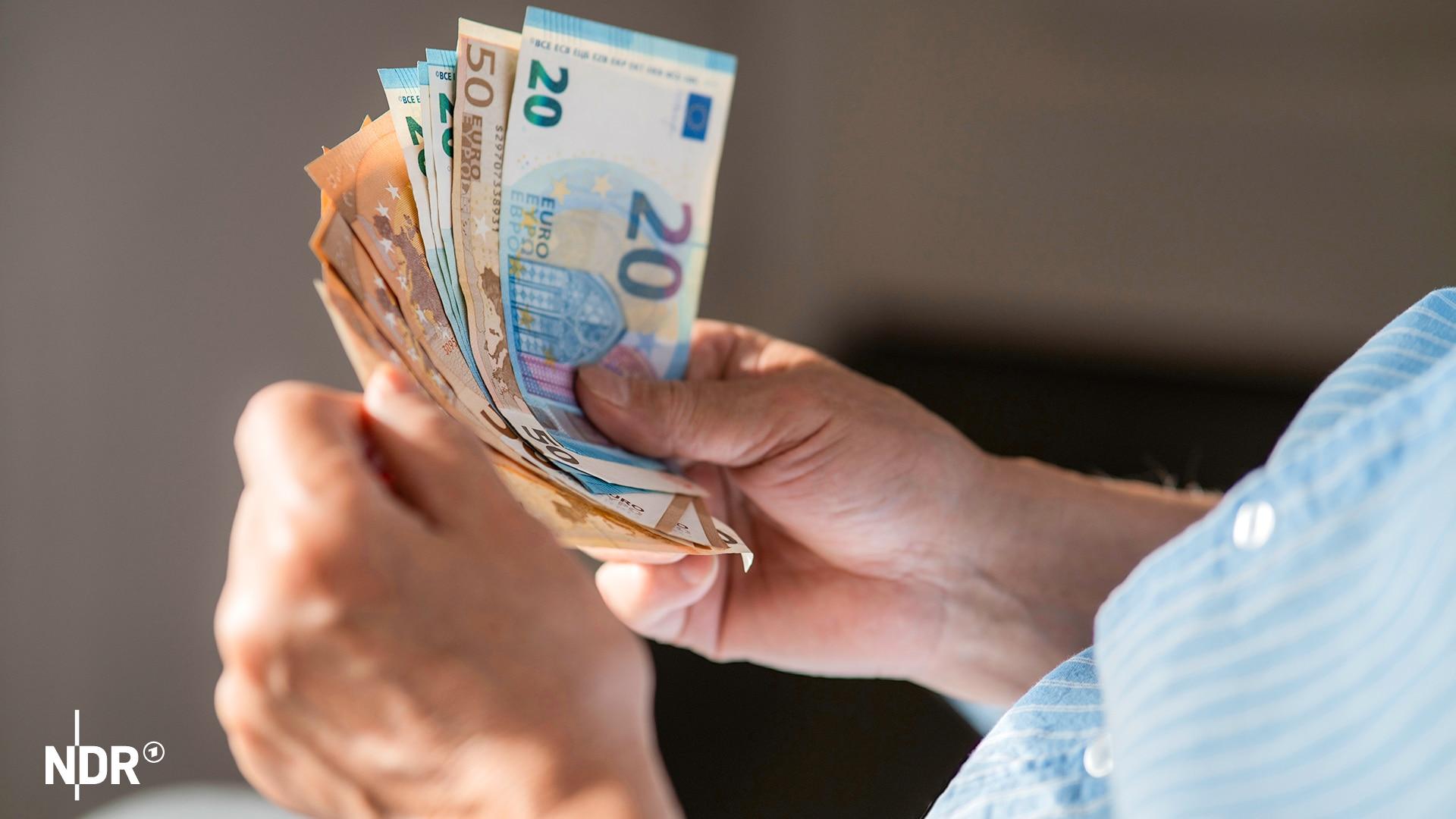 Ein Angestellter der Klinik soll Patienten Bargeld, EC-Karten und Schmuck gestohlen haben. Der Mann wurde laut Polizei auf frischer Tat ertappt. (Themenbild) | panthermedia.net/Westend61Premium (Arman Zhenikeyev) Eine männliche Person hält einige Euroscheine in den Händen und scheint diese zu zählen