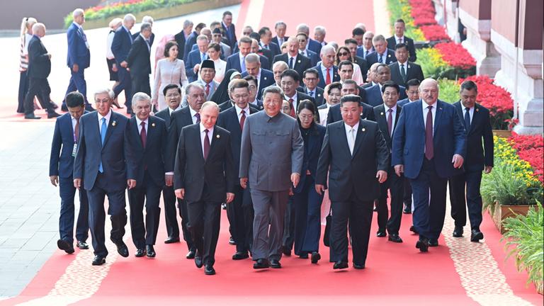 Wladimir Putin, Xi Jinping und Kim Jong Un vor anderen Besuchern einer Militärparade in Peking.