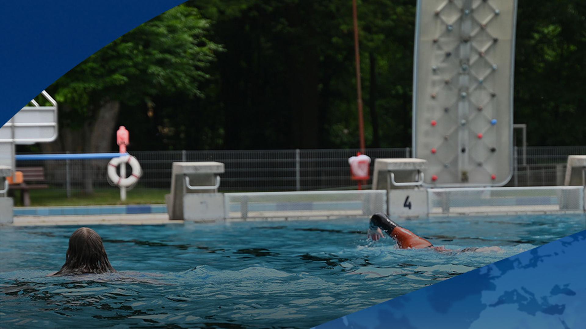 Ein Freibadbecken mit StartblÃ¶cken. Im Wasser sind zwei Personen die schwimmen. | dpa