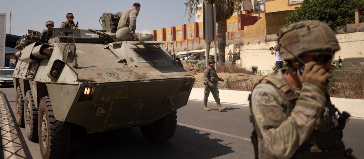 Spanische Soldaten und ein Panzer patrouillieren am Grenzzaum zwischen Ceuta und Marokko